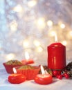 Close up of muffins in a red wrapper with red candles and holiday wreath. Bokeh background with a shallow depth of field. Royalty Free Stock Photo