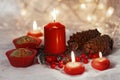 Close up of muffins in a red wrapper with red candles and holiday wreath. Bokeh background with a shallow depth of field. Royalty Free Stock Photo