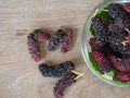 Close up of mulberry with a green leaves on the wooden plate on wooden table. Mulberry this a fruit and can be eaten in have a red Royalty Free Stock Photo