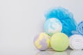 A close-up of multi-colored bath salts, in the form of bombs, a washcloth for the body and towels wrapped in a roll, there is a