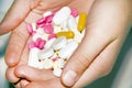 Close-up of multi-colored pills and capsules on the open palm of a painkiller pill