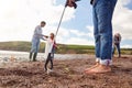 Close Up Of Multi-Generation Family Collecting Litter On Winter Beach Clean Up