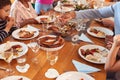 Close Up Of Multi-Generation Family Sitting Around Table Enjoying Meal At Home Together Royalty Free Stock Photo