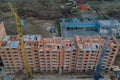 Close-up on a multi-storey residential building under construction from red brick with a part of a crane. The walls of the house Royalty Free Stock Photo