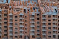 Close-up on a multi-storey residential building under construction from red brick with a part of a crane. The walls of the house Royalty Free Stock Photo