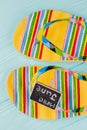 Close-up multicolored sandals on blue desk.