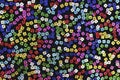 Close up of Multicolored sequins on black fabric.