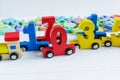 Close up Multicolored wooden numbers on white wooden background. Set of toys for studying mathematics. Education, back to school