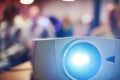 Close-up multimedia projector with blurred people background. Royalty Free Stock Photo