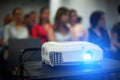Close-up multimedia projector with blurred people background. Royalty Free Stock Photo