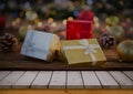 Close-up of multiple christmas presents with baubles on wooden table by white surface, copy space