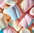 Close up of multiple colourful marshmallows lying on pink background