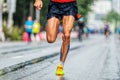 close-up muscular legs male runner running marathon city race Royalty Free Stock Photo