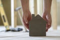 Close-up of muscular male hands holding small brown wooden model Royalty Free Stock Photo