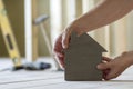 Close-up of muscular male hands holding small brown wooden model Royalty Free Stock Photo