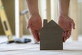 Close-up of muscular male hands holding small brown wooden model Royalty Free Stock Photo