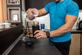 Close up of a muscular man making a shake in the kitchen of his flat