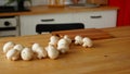 Close up of mushrooms on kitchen table. Small white mushrooms scattered on table in kitchen. Royalty Free Stock Photo