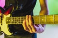 Close up musician hands playing bass guitar on gradient studio background in neon light Royalty Free Stock Photo