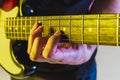 Close up musician hands playing bass guitar on gradient studio background in neon light Royalty Free Stock Photo