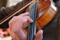 Close up of musician's hands on neck of violin