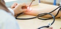 Close-up muslim female doctor using sphygmomanometer with stethoscope checking blood pressure to patient in the hospital Royalty Free Stock Photo