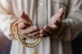 Close up of a Muslim mans hands praying and holding prayer beads. Royalty Free Stock Photo