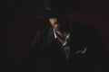 Close up of mysterious young man in tuxedo on black background