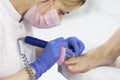 Close-up nail care by a pedicure specialist in a beauty salon. Pedicure transparent cuticle professional scissors for pedicure