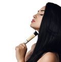 Close up naked woman in profile brunette with closed eyes holding a small tube of cream on white. Advertisement concept