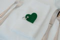 a pair of silverware and green felt heart in a napkin Royalty Free Stock Photo