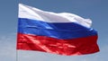 Close-up of the national flag of the Russian Federation fluttering in the wind against a blue sky