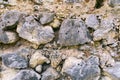 Close-up of a natural, uneven, multicolored stone wall texture composed of rough-hewn rocks and irregular pebbles Royalty Free Stock Photo