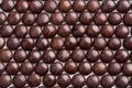 Close up neatly arranged brown milk chocolate candies crisp shell Royalty Free Stock Photo