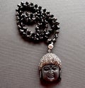 Close up of a necklace made of black crystals and buddha head Royalty Free Stock Photo