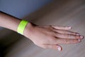 close-up of neon yellow paper bracelet on the male arm of child clinic patient, check tape with entry number on hand of middle-