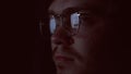 Close up of nerd face reading data reflected in glasses, working late. Concept. Clever nformation analytic or internet