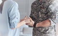 Close up of nervous wife holding hands of military husband