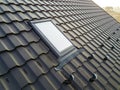 Close-up of new attic plastic window installed in shingled house roof. Professionally done building and construction work, roofing Royalty Free Stock Photo