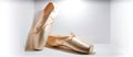Close-up new beige pink ballerina pointe shoes in wall niche,light background,side view,copy space.Training accessories