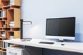 Close up of designer office interior with creative wooden bookcase, empty computer monitor and other items. Mock up, 3D Royalty Free Stock Photo