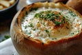 Close-up of New England Clam Chowder in a bread bowl with parsley. Thick creamy soup of shellfish and vegetables Royalty Free Stock Photo