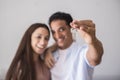 Close up of new home keys and young interracial couple smile and show the property - new life mortage house buyers people concept Royalty Free Stock Photo