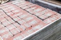 Close-up of new red paver stones in pallet fixed with stretch wrap. Blocks texture, background, material for pavement.