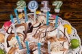 Close up of new year cake with lots of candles and macarons near