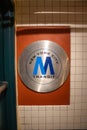 Close-up of the New York Transit logo on a tiled wall