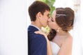 Close-up of the newlyweds kiss gently on the lips on their wedding day in the Greek style.