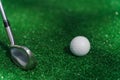 Close-up niblick and white ball for golf on the green grass. Empty right side for text of advert for golf clubs. Playing Royalty Free Stock Photo