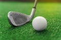 Close-up niblick and white ball for golf on the green grass. Empty right side for text of advert for golf clubs. Playing Royalty Free Stock Photo