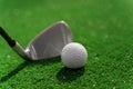 Close-up niblick and white ball for golf on the green grass. Empty right side for text of advert for golf clubs. Playing Royalty Free Stock Photo